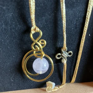 Medaglione in ottone con selenite, cordino in tessuto